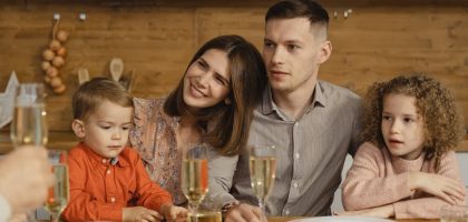 A joyful family gathers for a festive dinner, exchanging warmth and togetherness.