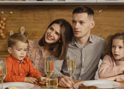 A joyful family gathers for a festive dinner, exchanging warmth and togetherness.