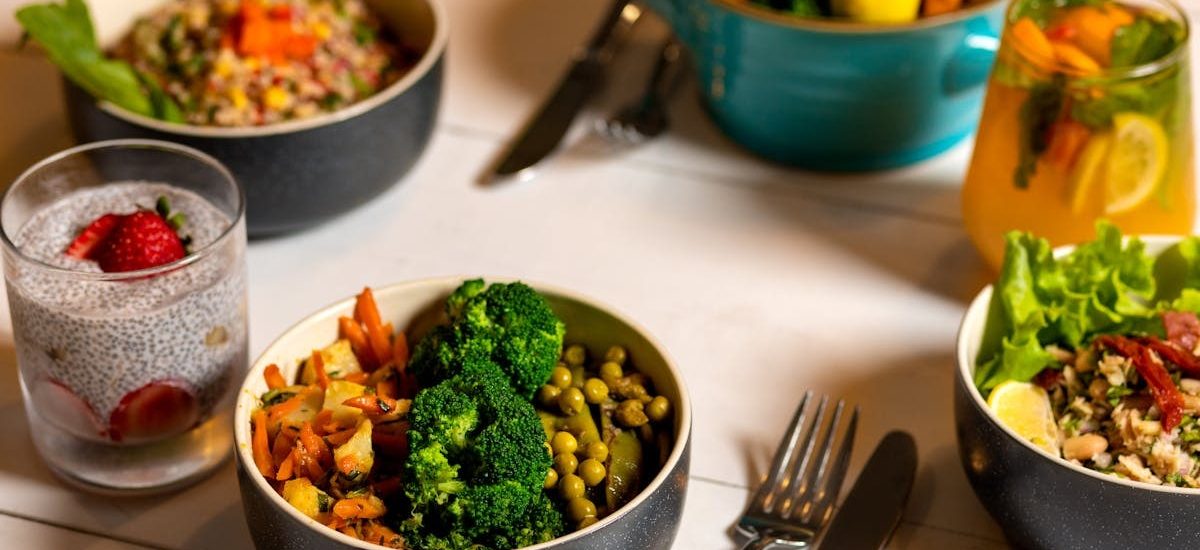 Delicious colorful bowls of salad and fresh beverages on a white table, perfect for healthy dining.
