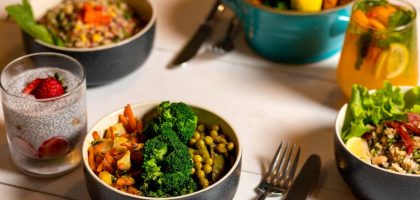 Delicious colorful bowls of salad and fresh beverages on a white table, perfect for healthy dining.