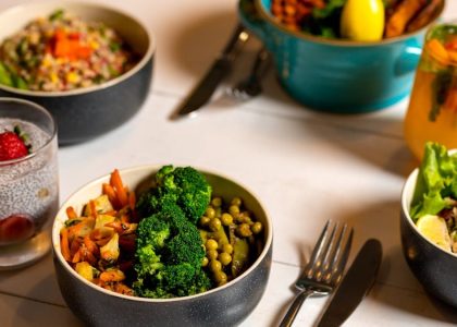 Delicious colorful bowls of salad and fresh beverages on a white table, perfect for healthy dining.